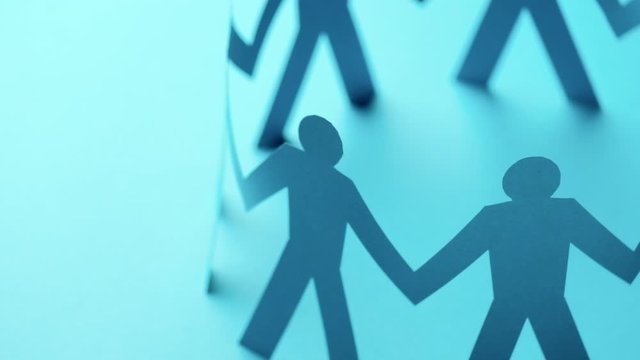 Concept of cooperation. Closed joining of paper figure in hand up posture on blue background. Successful and leadership.