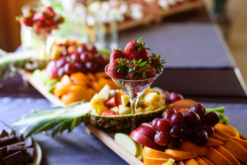 Strawberry, grapes, apple, pineapple and other fruits on banquet table, catering
