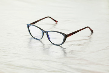 Fototapeta na wymiar Fashionable stylish glasses on metalized background. Optics. Vision.