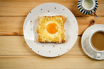 breakfast set with coffee and toast with egg on wooden table