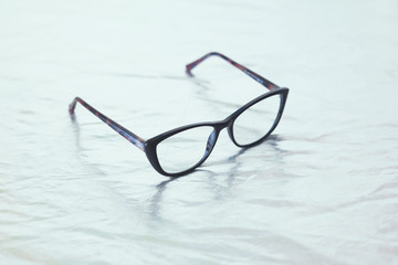 Fototapeta na wymiar Fashionable stylish glasses on metalized background. Optics. Vision.