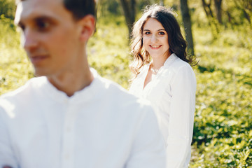 bright and happy pregnant woman walking in the park with her husband
