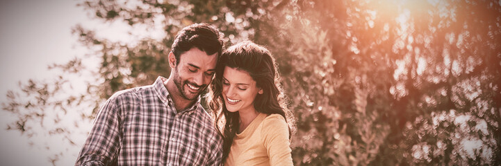 Fototapeta premium Young couple using mobile phone at farm