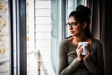 Woman with coffee cup by window