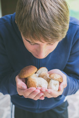 boy holding boletus edulis mushrooms freshly picked - raw food and healthy lifestyle