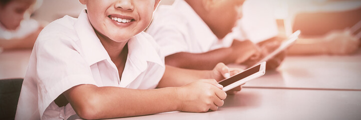 School kids using mobile phone in classroom