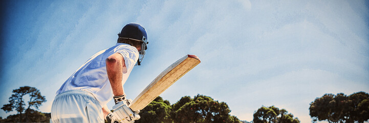 Side view of cricket player batting while playing on field