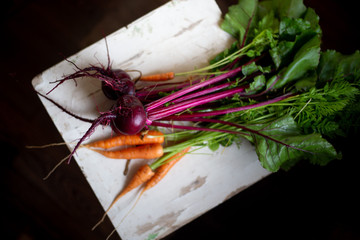 Fresh carrot and beetroot on old wooden background