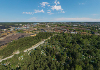 Forest cemetery and industrial area in Rezh city. Sverdlovsk region, Russia. Aerial, summer, sunny