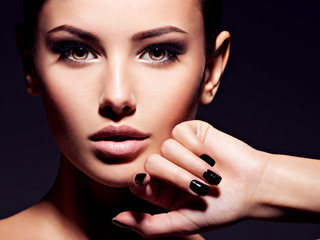 Face of a beautiful girl with fashion makeup and black nails
