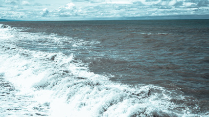 A breaking wave and stormy blue sea - panorama format