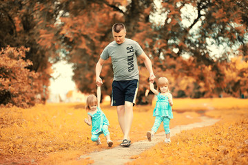 Fototapeta premium Mom with two daughters twins autumn