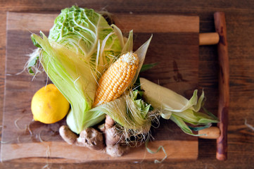  Semi-peeled corn and cabbage on a wooden board