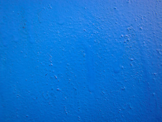 Wall covered with old blue paint. Swells and smudges.