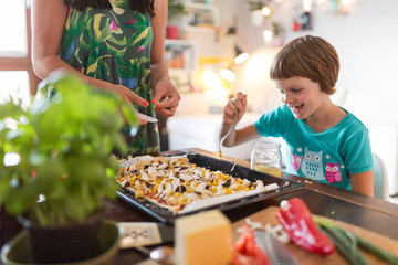 Mother and daughter preparing pizza at home
