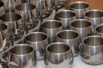 Set of dishes for drinks made of food steel, piles, bowls and wi