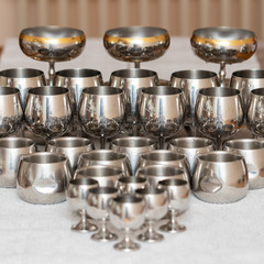 A set of dishes for drinks made of food steel, piles, bowls and