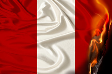 orange flames and ashes on the burning national flag of the state of Peru, the concept of revolution, war, coup, destruction, fires in the country, close-up