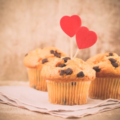 Homemade chocolate muffins with heart, vintage background.