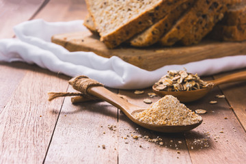 close-up of bread flour in wooden spoon on table