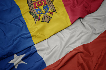 waving colorful flag of chile and national flag of moldova.