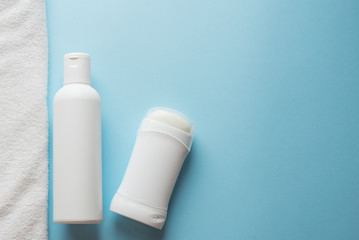 deodorant, lotion and towel on blue background , copy space, template