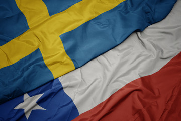 waving colorful flag of chile and national flag of sweden.