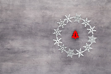 White snow flakes wreath decorations on gray background.