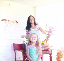 A young girl with a daughter is picking up a bouquet. A young mother with her daughter makes a...