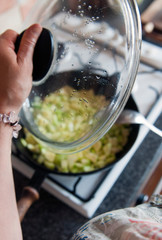  The hostess's hand mixes the sliced ​​vegetables on the pan with a metal spoon