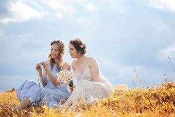 Two girls in dresses in autumn field