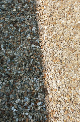 A photo of small stones, one part in the shade, one lit by the sun
