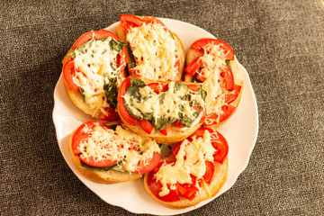 making sandwiches with tomato and basil on a baking sheet for the oven