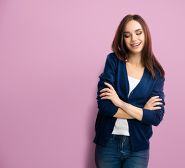 Young smiling woman in casual smart blue clothing with crossed arms, with copy space for slogan or...