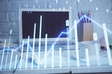 Forex graph hologram on table with computer background. Multi exposure. Concept of financial markets.