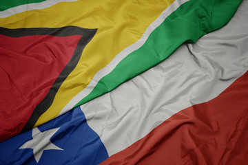 waving colorful flag of chile and national flag of guyana.