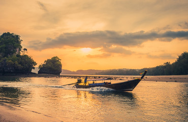 Traditional thai longtail boat at sunset beach. Ao Nang, Krabi province.