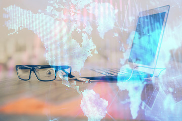 Stock market graph on background with desk and personal computer. Double exposure. Concept of financial analysis.