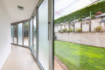 Corridor with white walls and large windows overlooking the private garden