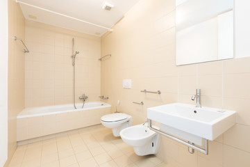 Fototapeta na wymiar Bath with modern beige tiles, new sanitary fixtures