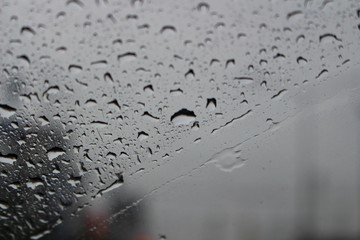 On the windshield of a car that ran on the road while it rained, there was a lot of water drops