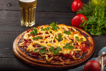 Homemade pizza with meat, sausage, cheese and tomatoes