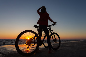 Fototapeta premium woman on bike enjoying the sunrise
