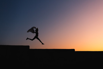 Silhouette of slim body woman jumping high