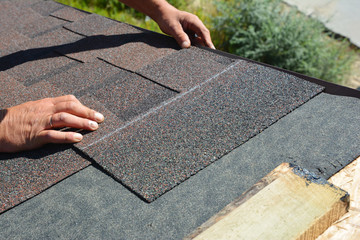 Asphalt Shingles Installation. Roofer Contractor Installing Asphalt Shingles on House Roofing...