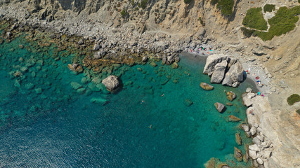 Aerial drone photo of iconic small chapel of Agia Anna built just above emerald rocky pebble beach,...