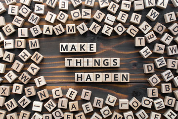 make things happen - phrase from wooden blocks with letters, keep it simple motivational concept, random letters around, white  background - Powered by Adobe