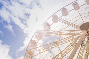 Ferris wheel on the colorful cloudy sky. Background concept of happy holidays time.