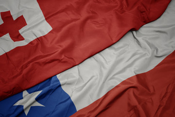 waving colorful flag of chile and national flag of Tonga .