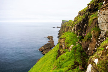 One of the picturesque Faroese Islands - Mykines with its cliffs and nesting birds above Atlantic Ocean.